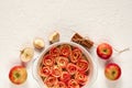 ÃÂpple rose tart decorated with fresh sliced apples and cinnamon sticks. Vegetarian autumn pie on the white background. Top view Royalty Free Stock Photo