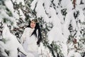 Portrait of a woman in white clothes in a cold winter forest. Girl with a wreath on her head in a snow-covered winter forest