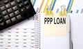 PPP LOAN text, written on a sticker with calculator,pen on chart background Royalty Free Stock Photo