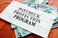 PPP Paycheck Protection Program as SBA loan written on the mask.