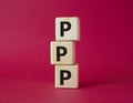PPP private public partnership symbol. Wooden cubes with words PPP. Beautiful red background. Business and PPP concept. Copy space