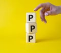 PPP private public partnership symbol. Wooden cubes with words PPP. Businessman hand. Beautiful yellow background. Business and