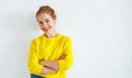 Ppy young woman in yellow sweater on white background