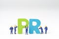 PR, Public Relations concept, miniature people staff help building color wooden letters forming word PR on white background with