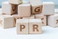 PR, Public Relations concept, wooden cube block with letters for Royalty Free Stock Photo