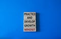Practice and Develop growth mindset symbol. Wooden blocks with words Practice and Develop growth mindset. Beautiful blue Royalty Free Stock Photo