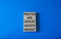Practice and Develop growth mindset symbol. Wooden blocks with words Practice and Develop growth mindset. Beautiful blue Royalty Free Stock Photo