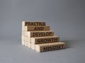 Practice and Develop growth mindset symbol. Wooden blocks with words Practice and Develop growth mindset. Beautiful grey