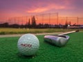 Practice golf ball with golf club in driving range with dramatic sky during sun set Royalty Free Stock Photo