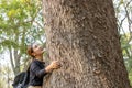 Woman hugging a big tree in the outdoor forest, Ecology and nature. Royalty Free Stock Photo