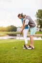 Practice makes perfect. an affectionate young couple spending a day on the golf course. Royalty Free Stock Photo