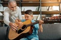 Loving grandfather and grandson having guitar practice Royalty Free Stock Photo