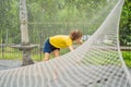 practice nets playground. boy plays in the playground shielded with a protective safety net. concept of children on line Royalty Free Stock Photo