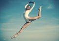 Practicing the art of classical ballet. Young ballerina jumping on blue sky. Pretty woman in dance wear. Cute ballet Royalty Free Stock Photo