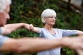 Practicing mindfulness. a senior woman holding hands with the people shes doing yoga with.