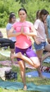 Practicing yoga. Young pretty girls taking pose for meditation at the city park