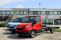 Three vans Iveco Daily chassis cab in a row outside the local dealer of the italian commercial vehicles automaker. Royalty Free Stock Photo