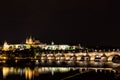 The Prague Castle and the Charles Bridge over Vltava river with nice water reflections at night in Prague, Czech Republic Royalty Free Stock Photo