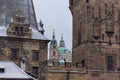 Prague, Charles Bridge with St. Nicolas Church behind Bridge Tower snow winter Royalty Free Stock Photo