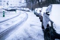 Prague city street under the snow. Cars driving on a blizzard road. Snow calamity in the city. Snow covered cars. Winter