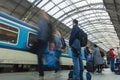 A guy waiting for the train at the Prague main train station with people boarding the blue train of Ceske Drahy