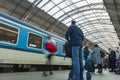 A guy waiting for the train at the Prague main train station with people boarding the blue train of Ceske Drahy