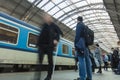 A guy waiting for the train at the Prague main train station with people boarding the blue train of Ceske Drahy