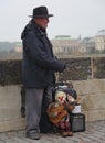 PRAGUE, CZECH - An old puppet master with a puppet performing on the Charles Bridge over Vltava. Royalty Free Stock Photo