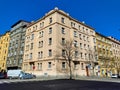 Old corner municipal apartment building with beige facade seen from the other side of crossroad Royalty Free Stock Photo