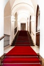 PRAGUE, CZECH REPUBLIC - April 1, 2022: Old Town Hall interior. Long corridor or lobby room with steps, red carpet and Royalty Free Stock Photo