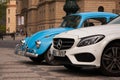 PRAGUE, CZECH REPUBLIC - APRIL 21, 2017: A small blue vintage Volkswagen Beetle car next to a big white Mercedes