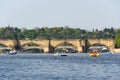 Tourist sailing on pedal boats on Vltava river near Charles bridge in Prague, Czech Republic