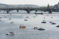 Tourist sailing on pedal boats on Vltava river near Charles bridge in Prague, Czech Republic