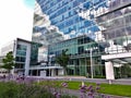 Entrance into high rise office building with blue sky in the background and flowers in the foreground Royalty Free Stock Photo