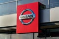 Nissan motor company logo in front of dealership building