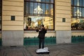 Prague, Czech Republic: an homeless violinist is playing on the sidewalk in front of a restaurant
