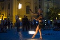 Prague, Czech Republic - July 22, 2019: Female fire dancer juggles with sticks on street of old town square in Prague. Fire show.