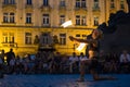 Prague, Czech Republic - July 22, 2019: Female fire dancer juggles with sticks on street of old town square in Prague. Fire show.