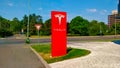 Big red column with Tesla sign for marking a car dealer selling Tesla cars