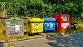 Colored trash cans for recyclable waster standing by the road Royalty Free Stock Photo