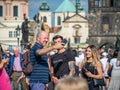 Happy tourists strolling and taking pictures on the famous Charles Bridge in Prague