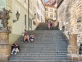 Scene fron the medieval old town in Prague with tourists resting on the stone steps to the Royalty Free Stock Photo