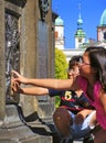 PRAGUE, CZECH REPUBLIC - JUNE 29, 2011: Two children touch relief on the pedestal of St. John of Nepomuk statue at Charles Bridge