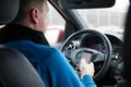Prague, Czech Republic - 21.01.1018: Man using smart phone in car during driving Royalty Free Stock Photo