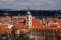 Prague, Czech Republic, 26 March 2023: Panorama of old town from Petrin Hill, Red roofs, Cloudy spring day, bell tower of Church
