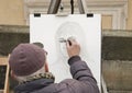 Prague, Czech Republic - March 14 2017: Street portrait artist sketch a woman