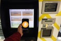 Prague, Czech Republic - May 18th 2019: Bitcoin ATM machine for buying and selling cryptocurrency. Male sells Bitcoins by ATM