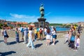 PRAGUE, CZECH REPUBLIC - MAY 28, 2017: Tourists touching a bronze plaque for luck on the St John of Nepomuk statue at Charles