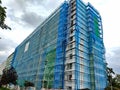 Transformation of an old communist-era apartment block, shrouded in vibrant blue scaffolding, undergoing reconstruction