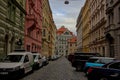 An atmospheric street in the old district of Prague is lined with buildings with colorful facades.